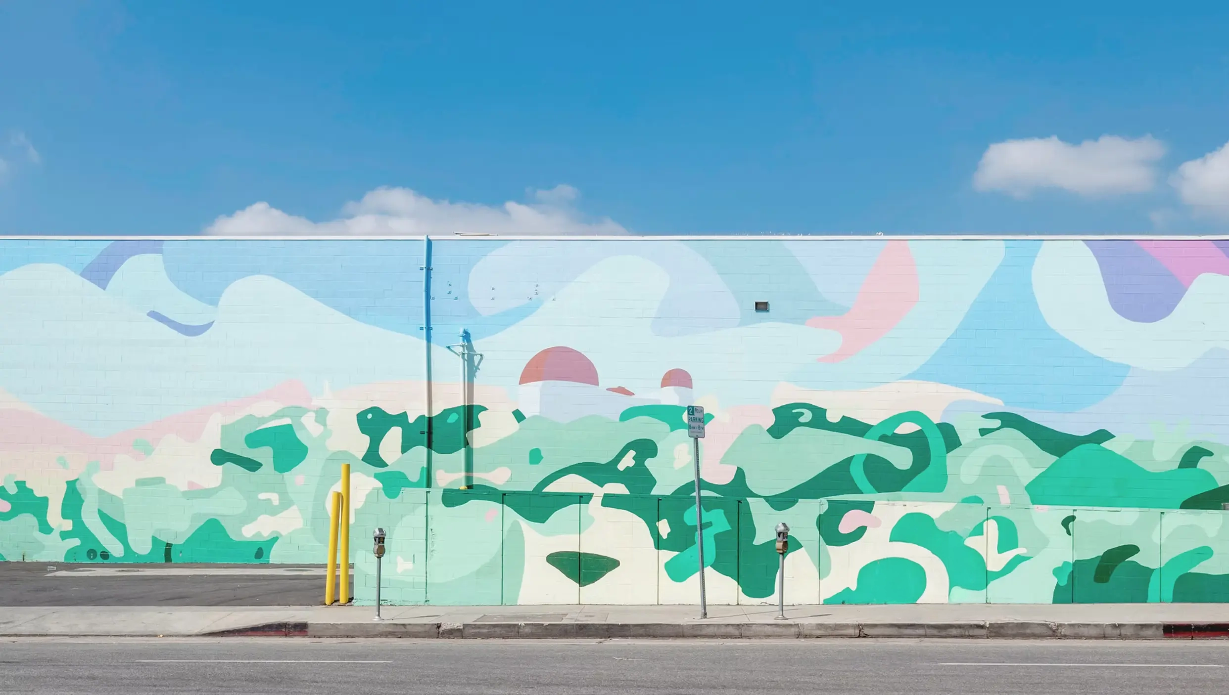 A long pastel mural of Griffith Observatory along a Los Angeles sidewalk.